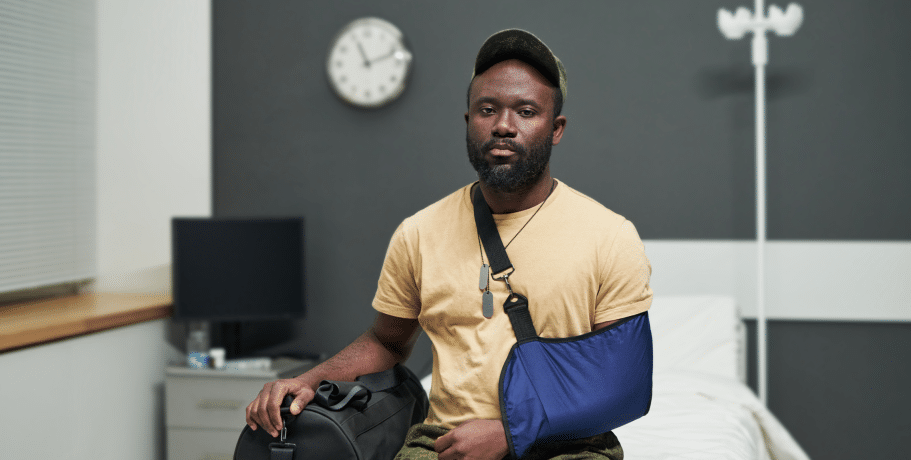 Construction worker who was injured at work, sitting in a doctor's office with his arm in a sling on Long Island