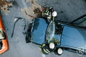 auto accident near garden city from a top-down view. two firefighters trying to access passengers in the black vehicle