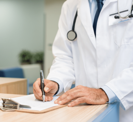 Doctor completing medical exam paperwork